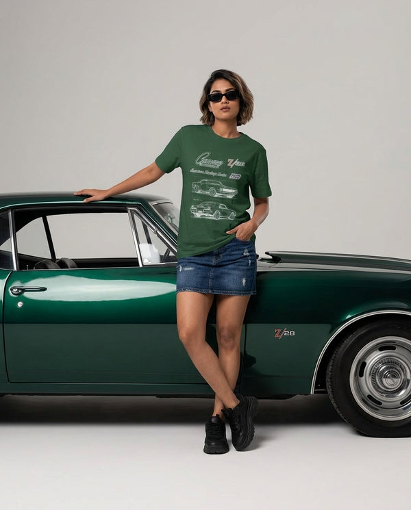 Woman in a green Camaro Z/28 round neck t-shirt leaning on a dark green classic car