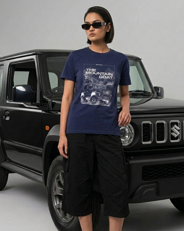 Woman in a navy Jimny regular fit t-shirt standing in front of a black Suzuki Jimny