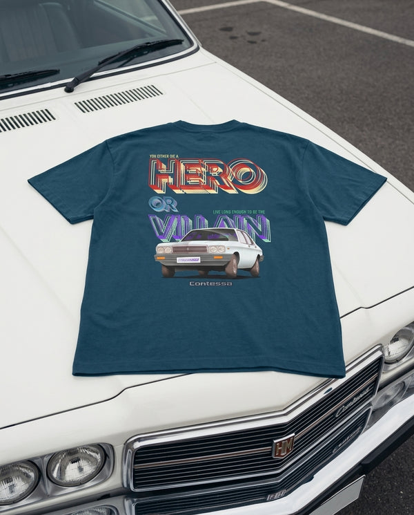 Teal Contessa Classic oversized tee with a Hero or Villain print, laid on the bonnet of a white car